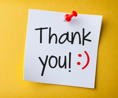 A post it note saying 'thank you' on a yellow background