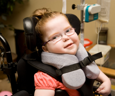 Young girl wearing glasses and using a wheelchair